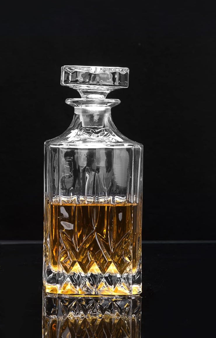Crystal decanter and glasses with whiskey on a black background