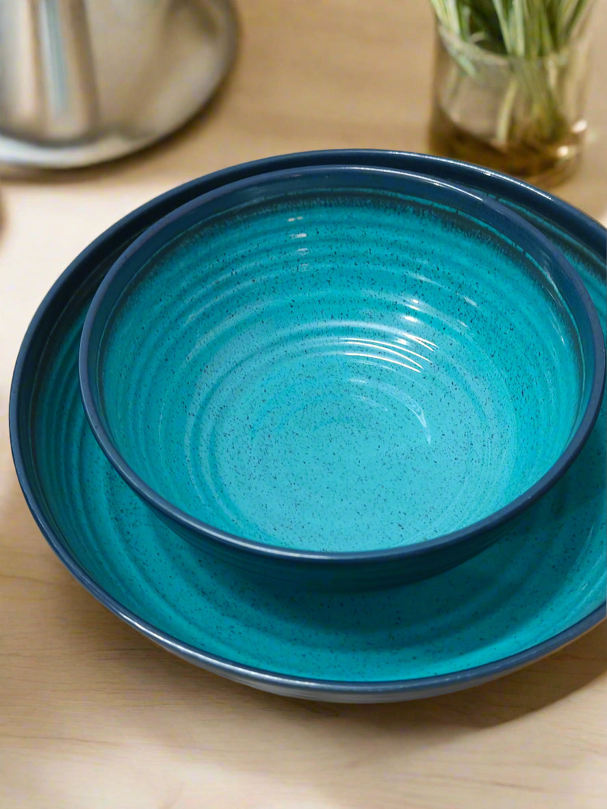 Two blue ceramic plates stacked on a wooden surface.